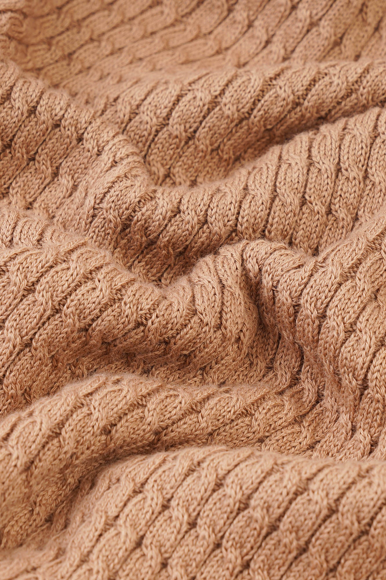 Image of Close-up of a brown textured fabric with cable knit pattern