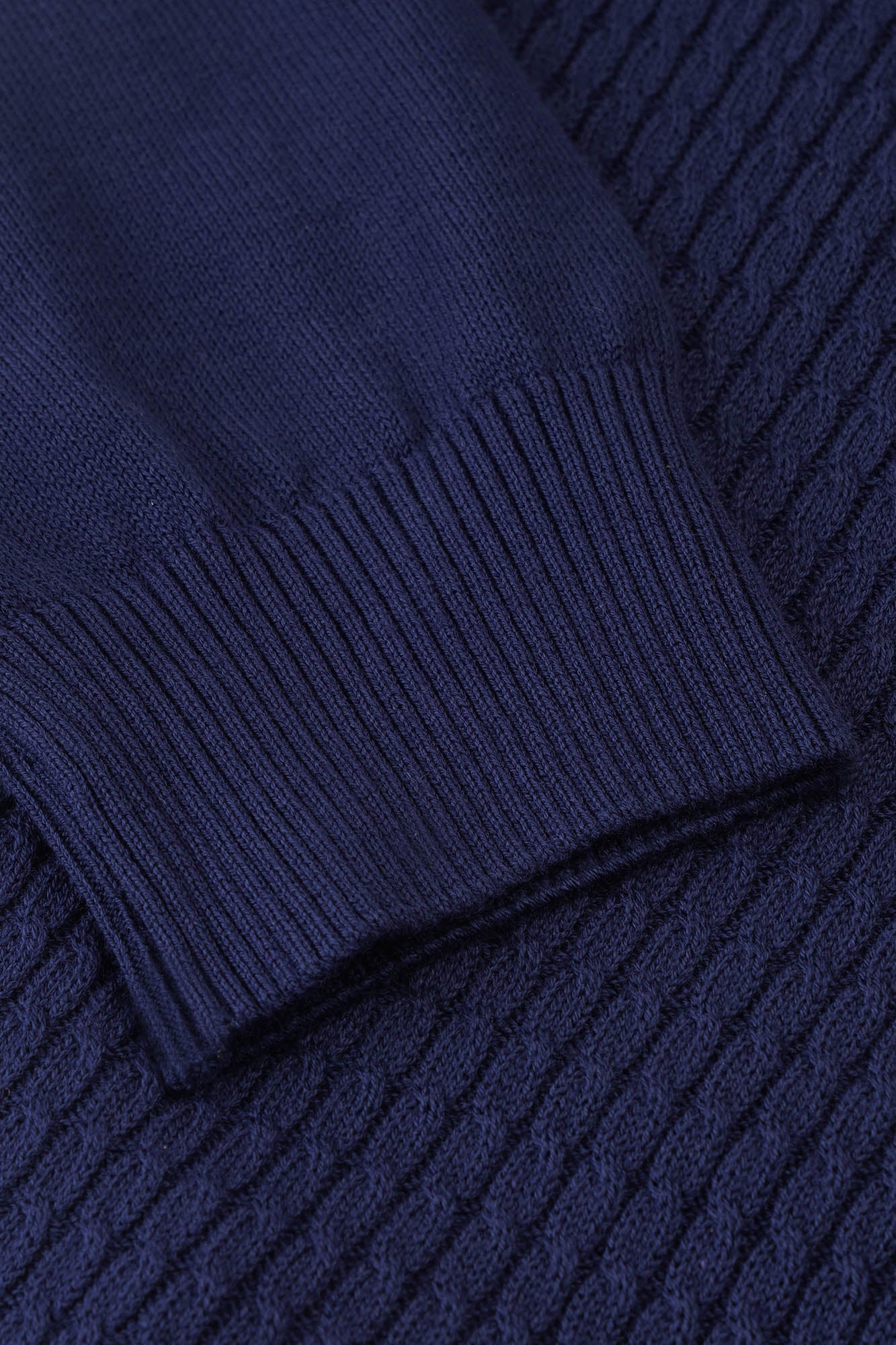 Image of Close-up of a navy blue sweater with ribbed texture