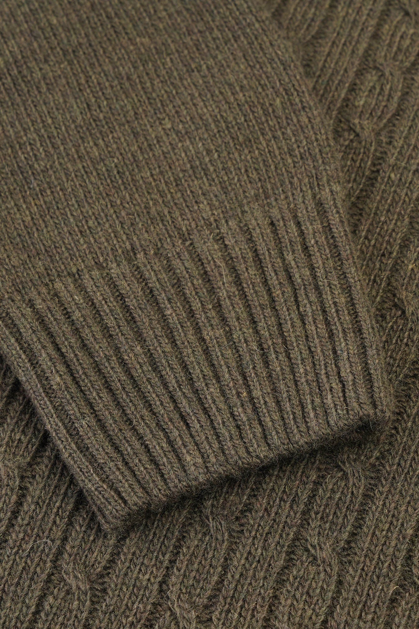 Image of Close-up of a brown knitted sweater with cable pattern