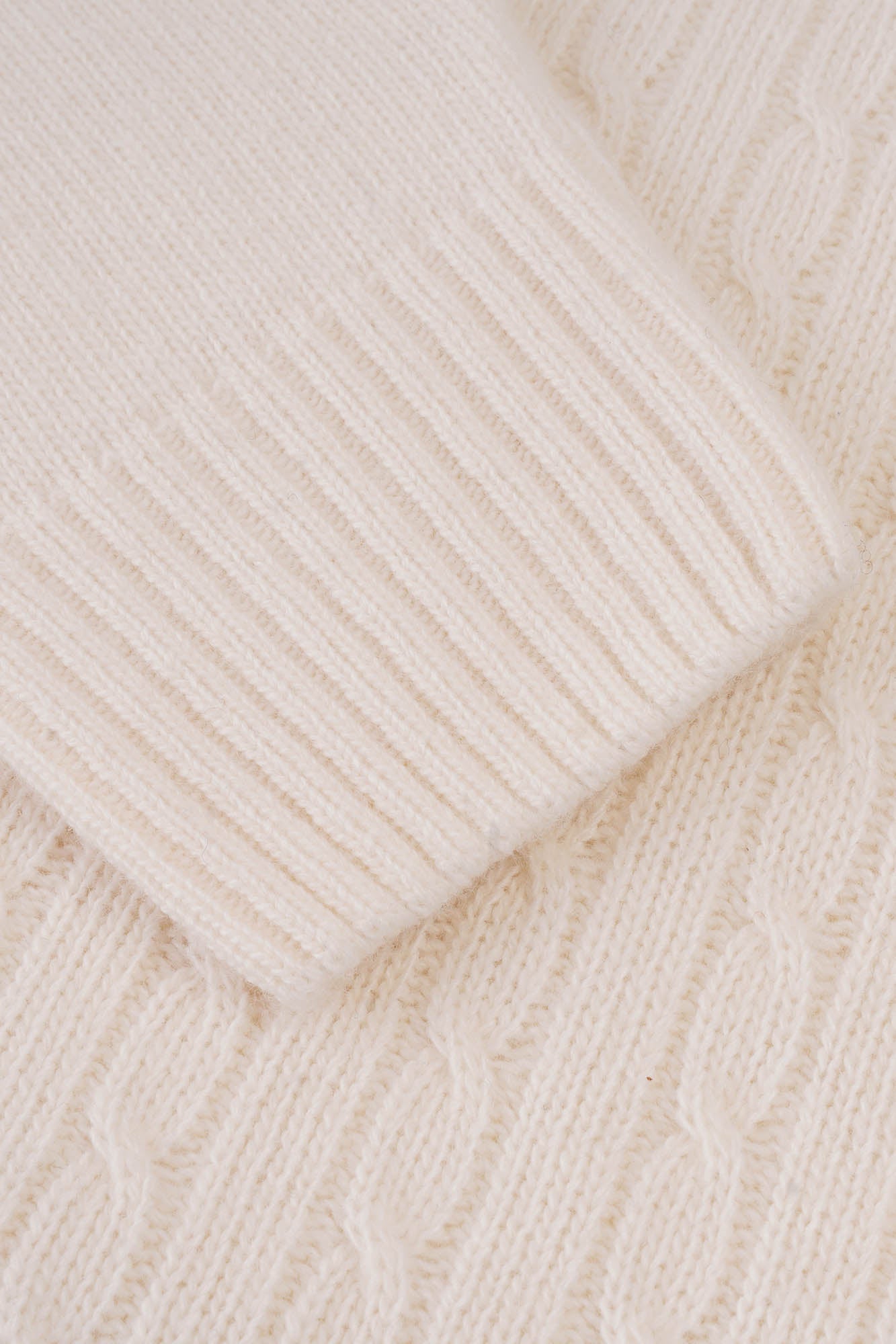 Image of Close-up of beige knitted fabric with a subtle pattern