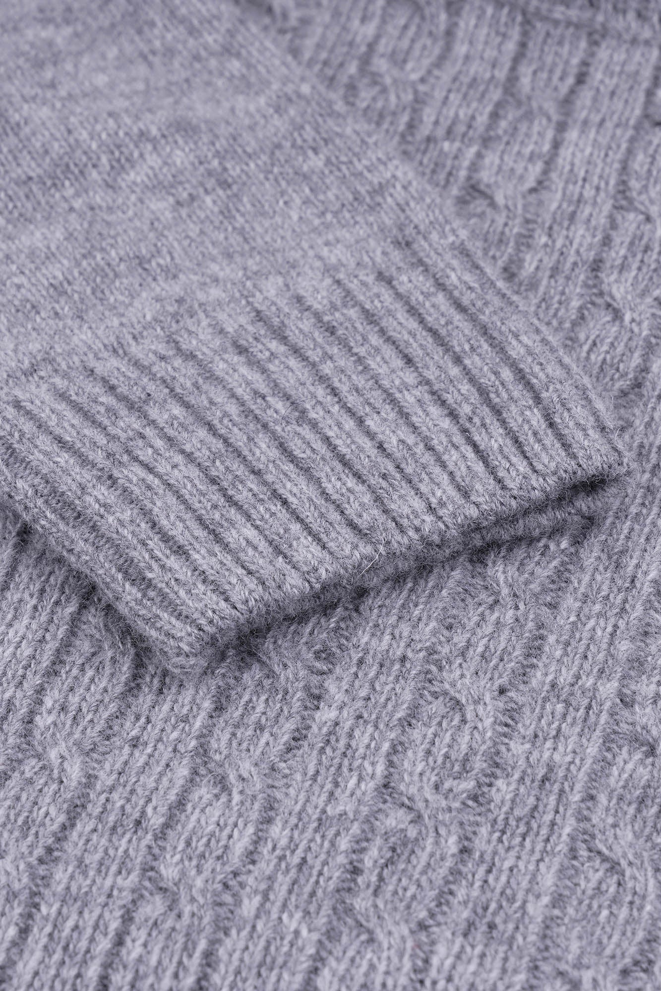 Image of Close-up of gray knitted fabric with a cable pattern